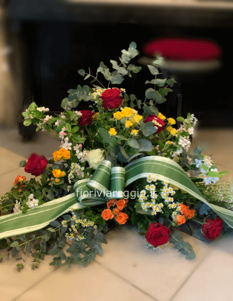 Composizione funebre a ventaglio con fiori di stagione